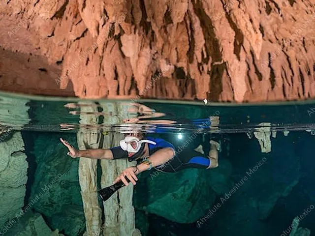 Geteilte Ansicht mit einem Schnorchler unter Wasser und herabhängenden Stalaktiten in einer Cenote.