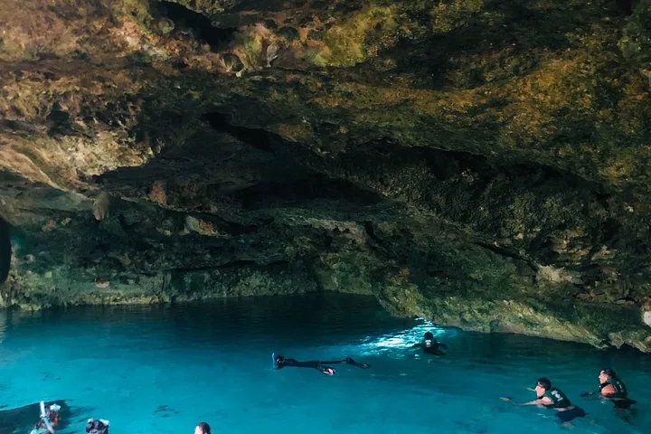 Schnorchler erkunden die klaren Gewässer unter den Felsformationen des Cenote Dos Ojos.